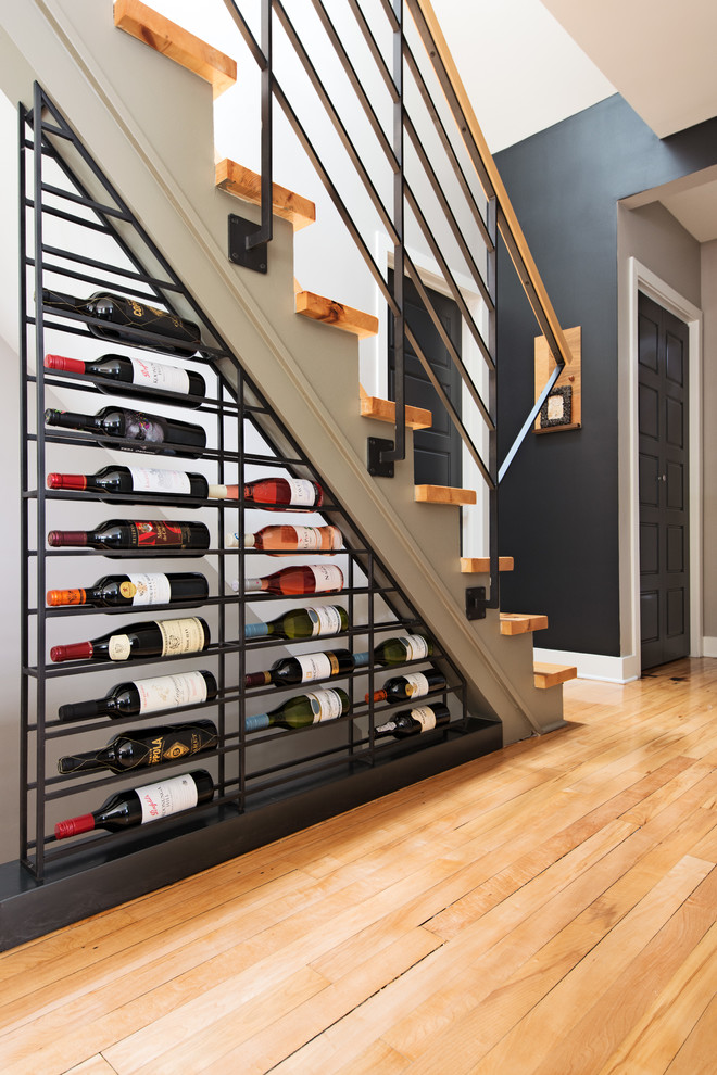 Design ideas for a contemporary wine cellar in Montreal with light hardwood floors, storage racks and yellow floor.