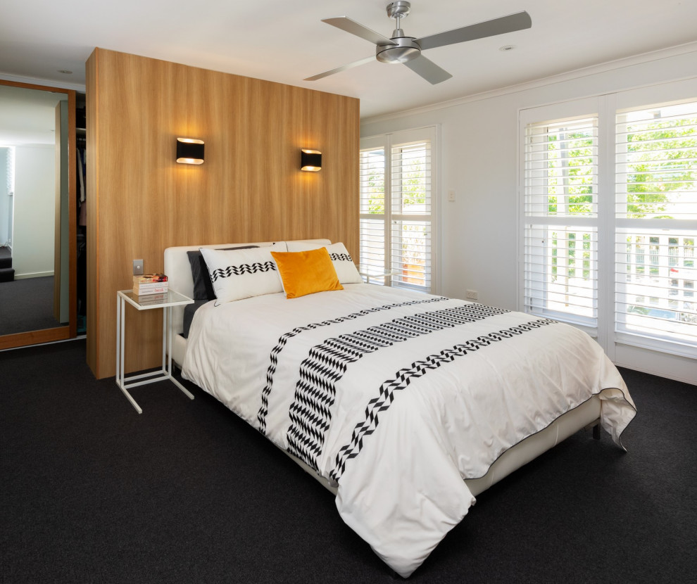 メルボルンにある中くらいなコンテンポラリースタイルのおしゃれな主寝室 (白い壁、カーペット敷き、黒い床、板張り壁)