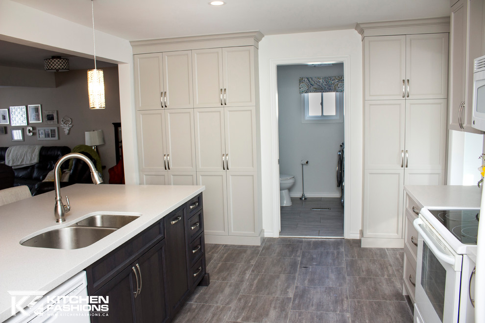 Example of a mid-sized transitional single-wall ceramic tile open concept kitchen design with an undermount sink, shaker cabinets, gray cabinets, solid surface countertops, gray backsplash, mosaic tile backsplash, white appliances and an island