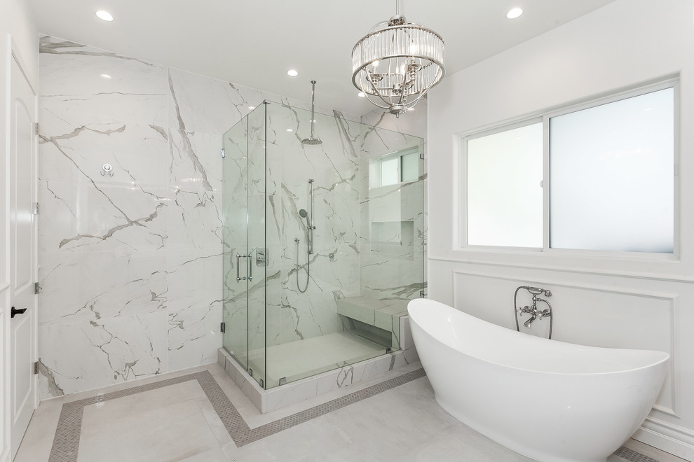 Inspiration for a mid-sized contemporary master bathroom in Los Angeles with a freestanding tub, a corner shower, multi-coloured tile, mosaic tile, flat-panel cabinets, white cabinets, a two-piece toilet, white walls, ceramic floors, a console sink, marble benchtops, white floor, a hinged shower door and white benchtops.