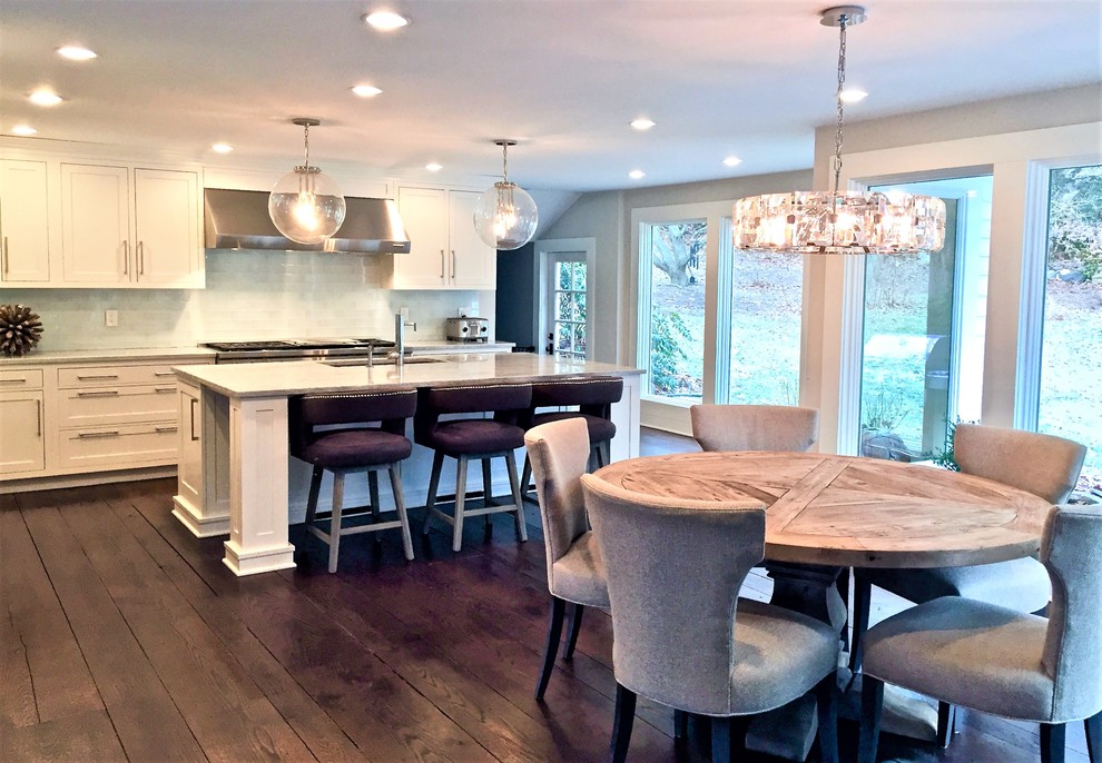 Example of a transitional l-shaped eat-in kitchen design in New York with shaker cabinets, white cabinets, quartz countertops, stainless steel appliances and an island