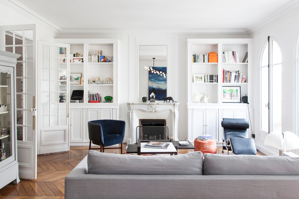 Inspiration for a transitional formal enclosed living room in Paris with white walls, medium hardwood floors, a standard fireplace, no tv and brown floor.