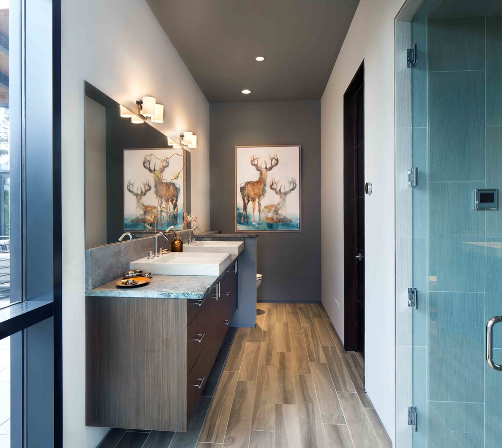 Design ideas for a large modern master bathroom in Other with a vessel sink, medium wood cabinets, granite benchtops, an alcove shower, a wall-mount toilet, white tile, grey walls and light hardwood floors.