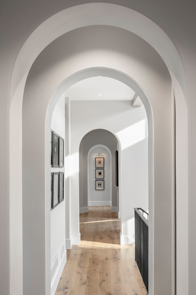 Idée de décoration pour un couloir minimaliste avec un mur blanc et parquet clair.