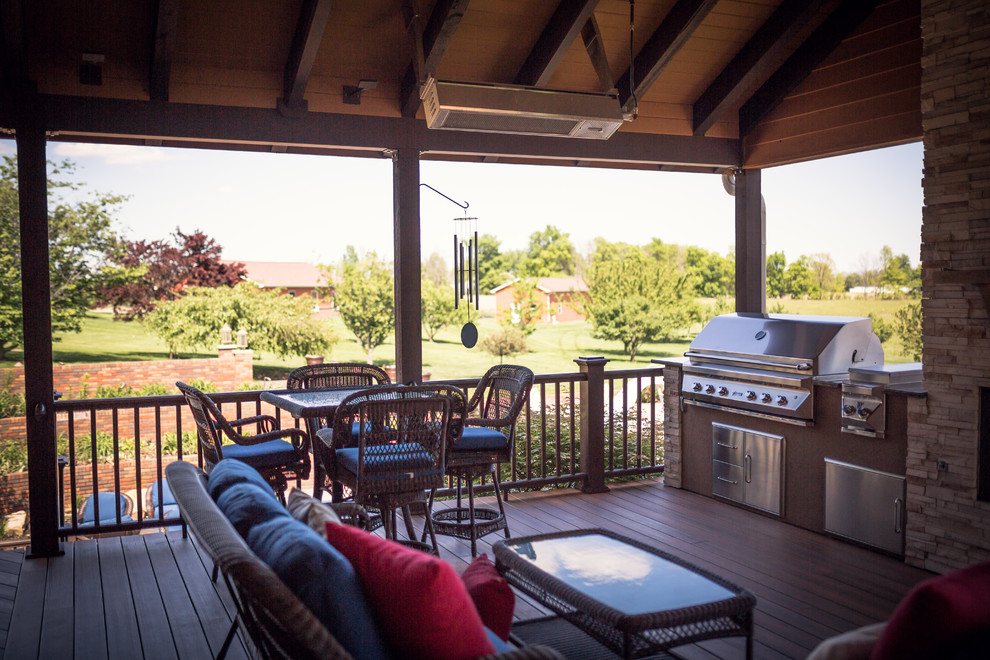 Inspiration for a huge rustic backyard outdoor kitchen deck remodel in Indianapolis with a roof extension