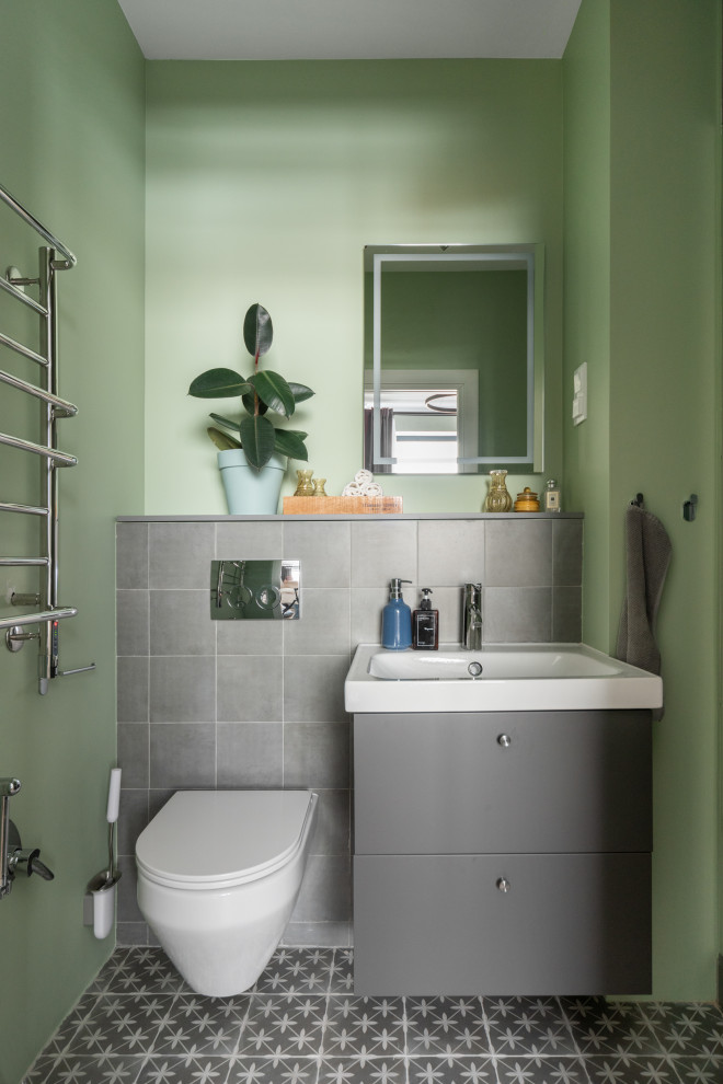 Modernes Badezimmer mit flächenbündigen Schrankfronten, grauen Schränken, Wandtoilette, grauen Fliesen, grüner Wandfarbe, Waschtischkonsole, grauem Boden, Einzelwaschbecken und schwebendem Waschtisch in Moskau