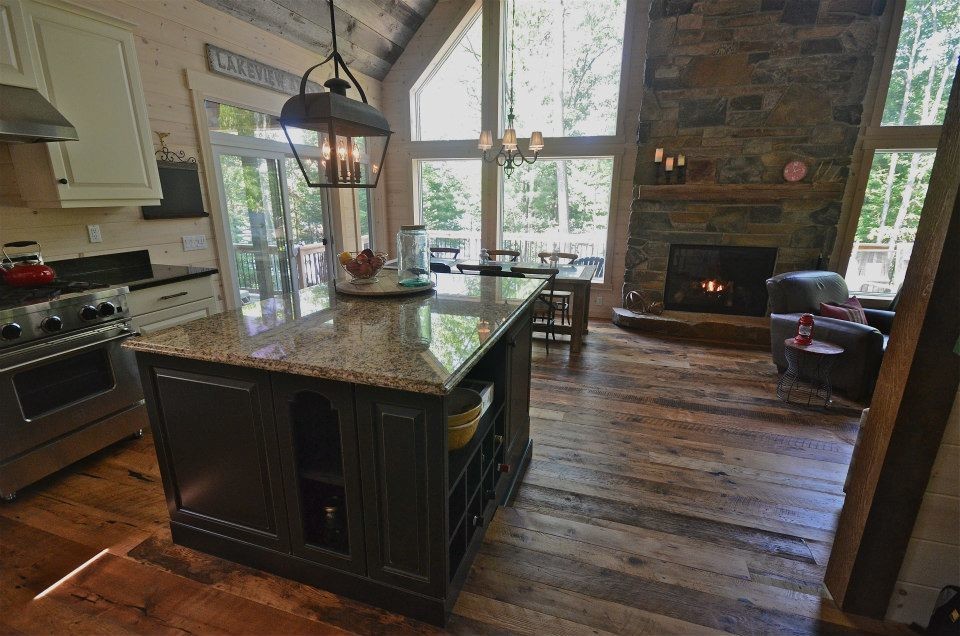Mid-sized mountain style l-shaped medium tone wood floor open concept kitchen photo in Toronto with an island, raised-panel cabinets, white cabinets, granite countertops, stainless steel appliances and a double-bowl sink