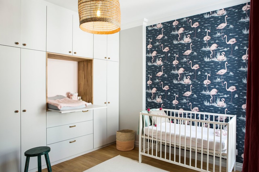 This is an example of a mid-sized midcentury nursery for girls in Paris with grey walls, light hardwood floors and beige floor.