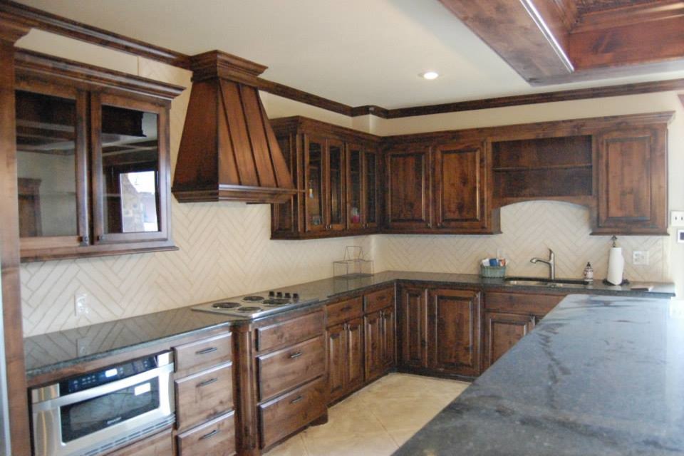 Inspiration for a large country u-shaped eat-in kitchen in Austin with a double-bowl sink, raised-panel cabinets, distressed cabinets, granite benchtops, white splashback, porcelain splashback, stainless steel appliances, travertine floors and with island.