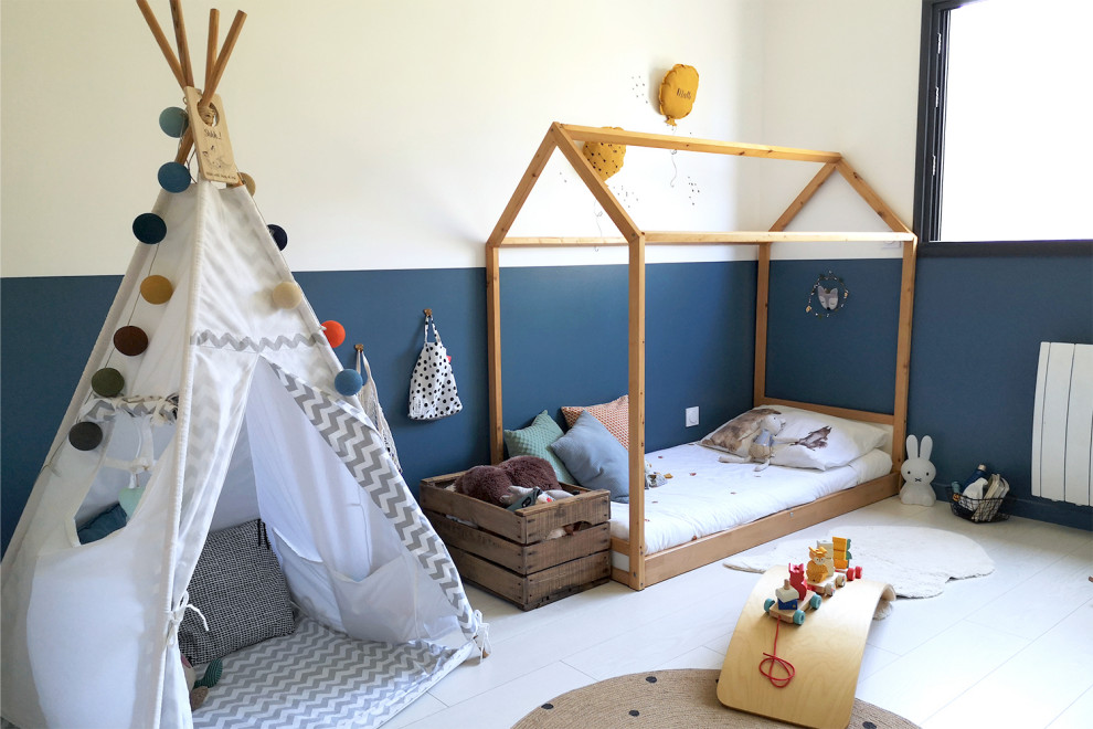 Inredning av ett minimalistiskt barnrum kombinerat med sovrum, med blå väggar, laminatgolv och vitt golv