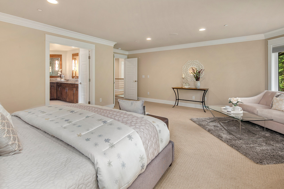 This is an example of a large transitional master bedroom in Seattle with beige walls and carpet.