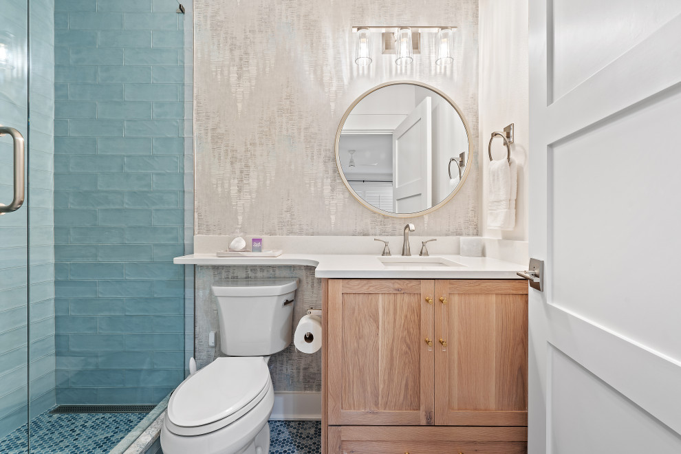 Beach style 3/4 mosaic tile floor, multicolored floor, single-sink and wallpaper alcove shower photo in Miami with shaker cabinets, medium tone wood cabinets, a two-piece toilet, an undermount sink, quartz countertops, a hinged shower door, white countertops and a built-in vanity