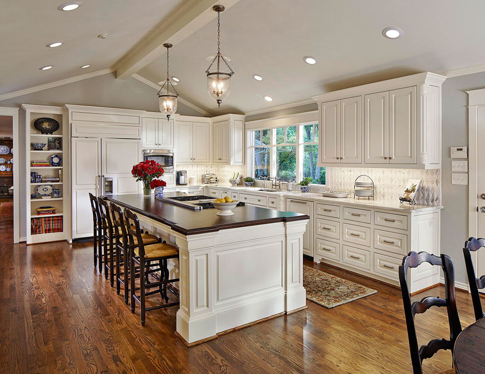 Eat-in kitchen - traditional u-shaped dark wood floor eat-in kitchen idea in Orange County with raised-panel cabinets, white cabinets, gray backsplash, stainless steel appliances and an island
