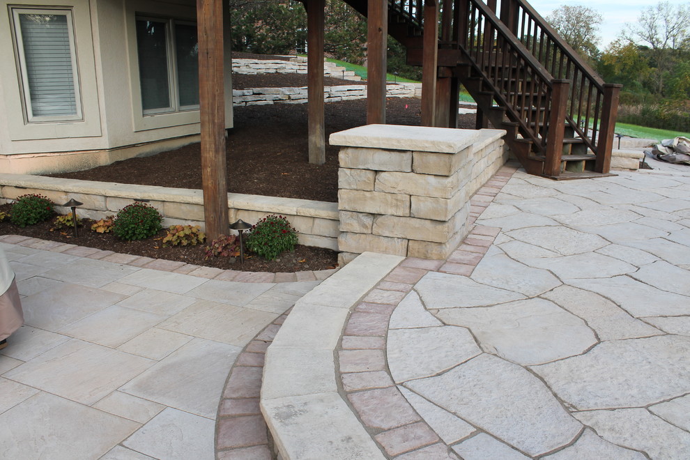 Photo of a mid-sized contemporary backyard patio in Chicago with a fire feature, natural stone pavers and no cover.