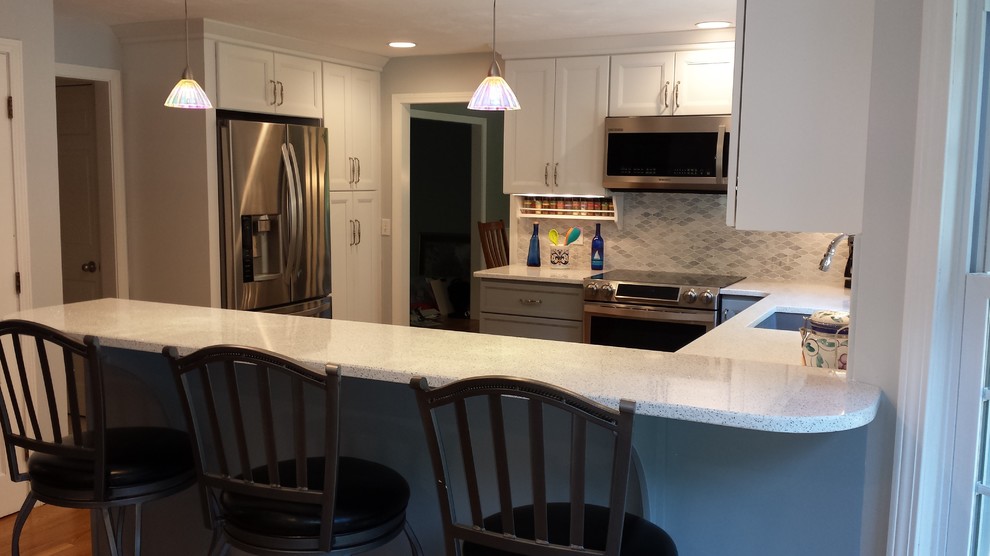 Mid-sized transitional u-shaped light wood floor kitchen photo in Boston with an undermount sink, quartz countertops, stainless steel appliances, a peninsula and multicolored backsplash