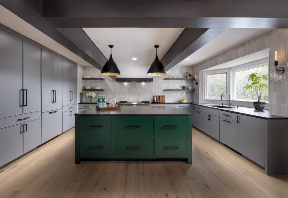Large trendy u-shaped light wood floor, beige floor and exposed beam eat-in kitchen photo in Detroit with an undermount sink, shaker cabinets, green cabinets, quartz countertops, gray backsplash, porcelain backsplash, paneled appliances, an island and black countertops