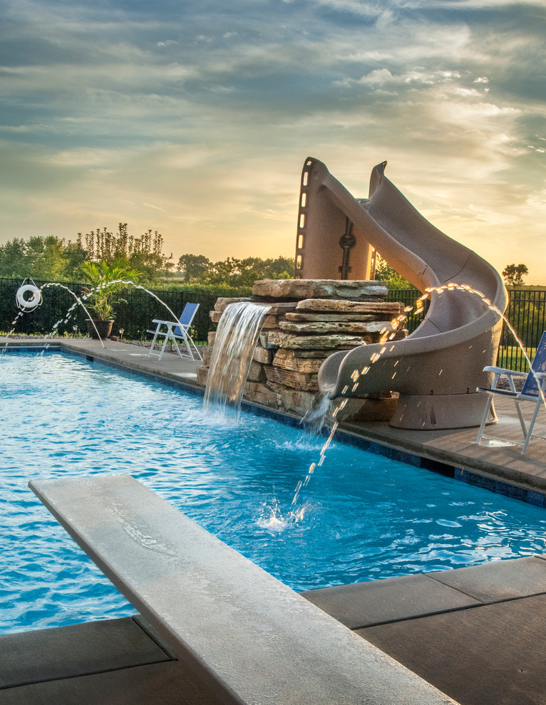 Mid-sized mountain style backyard concrete and rectangular lap pool fountain photo in Chicago