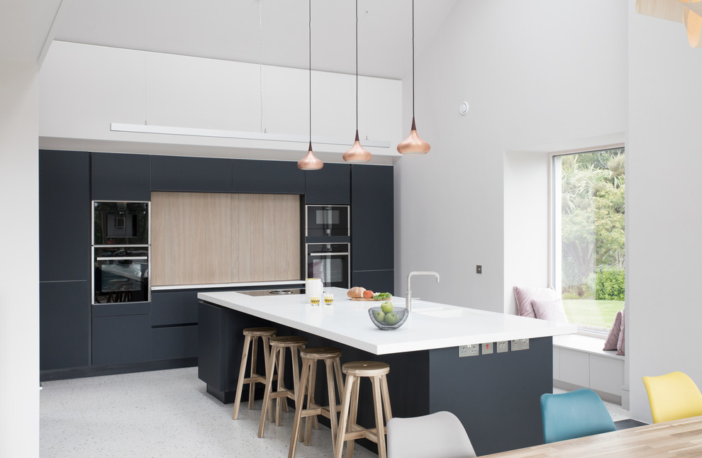 Design ideas for a large contemporary single-wall kitchen in Other with an integrated sink, solid surface benchtops, black appliances, concrete floors, with island, grey floor, flat-panel cabinets and black splashback.