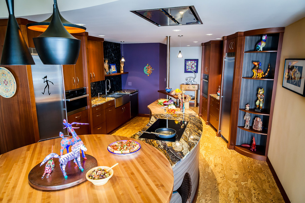 Design ideas for a large eclectic galley kitchen in Portland with a farmhouse sink, flat-panel cabinets, medium wood cabinets, granite benchtops, black splashback, marble splashback, stainless steel appliances, cork floors and purple benchtop.