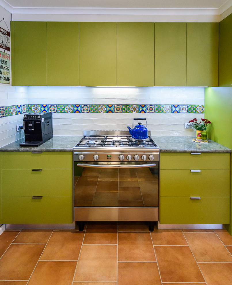 Mid-sized eclectic kitchen in Melbourne with a drop-in sink, flat-panel cabinets, green cabinets, laminate benchtops, multi-coloured splashback, ceramic splashback, stainless steel appliances, ceramic floors and with island.