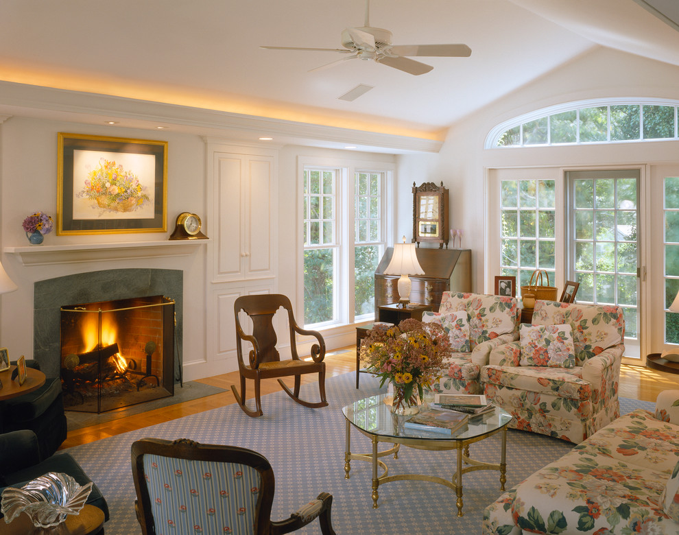 Traditional living room in Boston with white walls, medium hardwood floors and a standard fireplace.