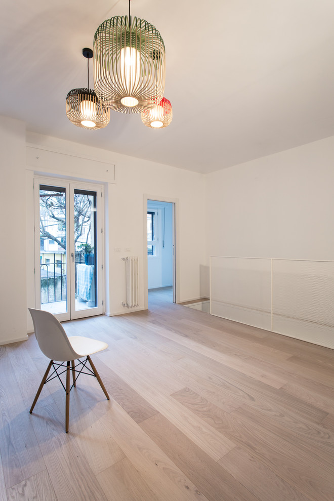 This is an example of an expansive scandinavian open concept living room in Milan with white walls and light hardwood floors.