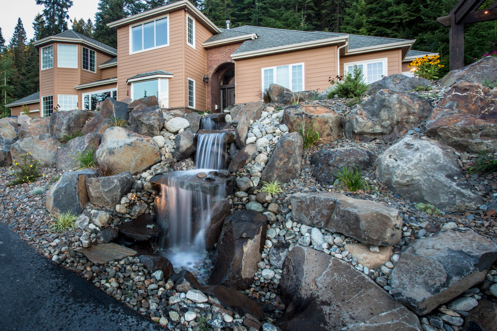 Photo of a mid-sized rustic front yard concrete paver water fountain landscape.