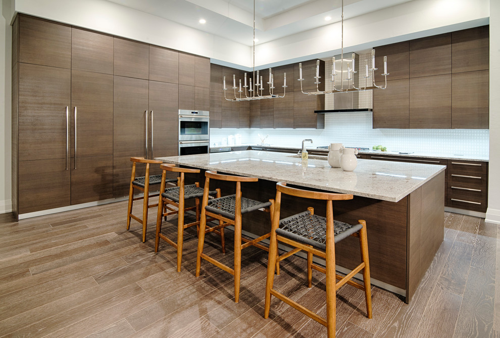 Contemporary l-shaped kitchen in Miami with flat-panel cabinets, dark wood cabinets, white splashback, stainless steel appliances, dark hardwood floors, with island, brown floor and white benchtop.