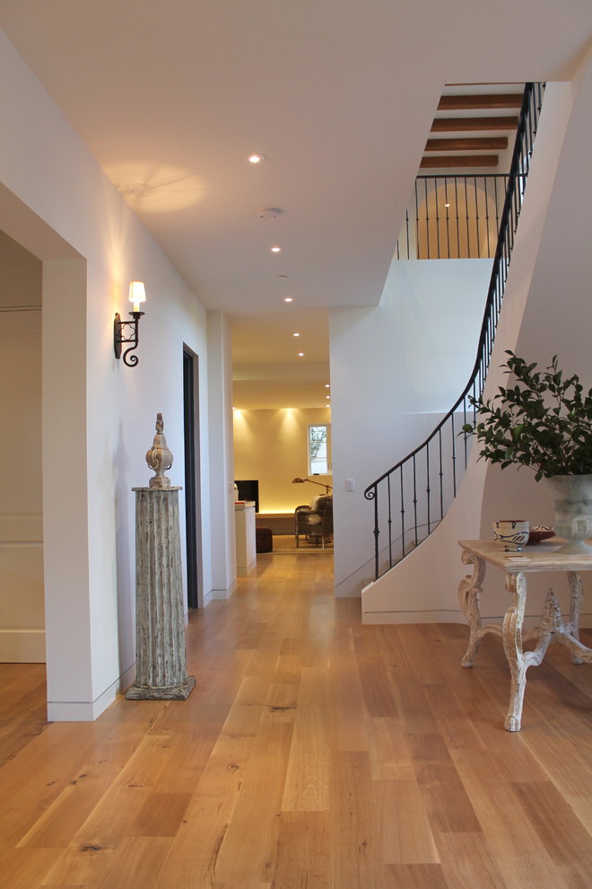 Inspiration for a large mediterranean hallway in San Francisco with white walls and light hardwood floors.