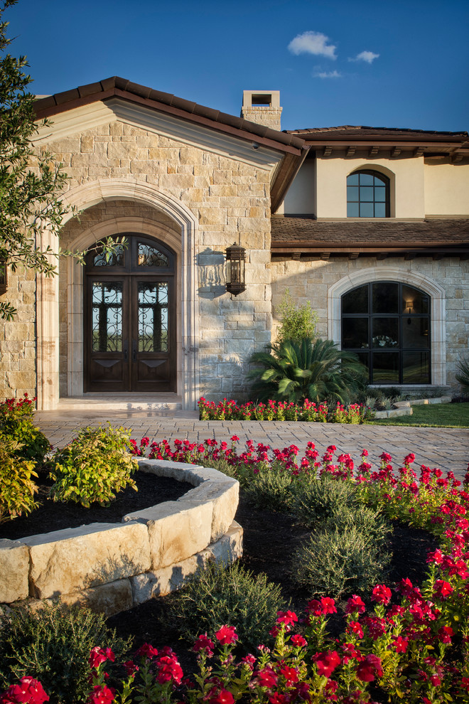 This is an example of an expansive mediterranean exterior in Austin with stone veneer.