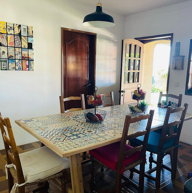 This is an example of a large mediterranean u-shaped kitchen/diner in Paris with a double-bowl sink, wood worktops, multi-coloured splashback, cement tile splashback, stainless steel appliances, ceramic flooring, an island, brown floors and black worktops.