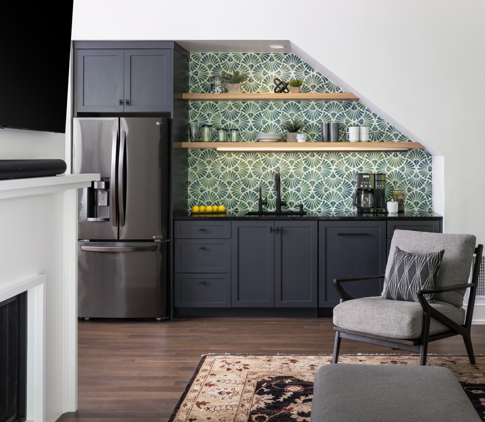 This is an example of a mid-sized transitional single-wall wet bar in Detroit with green splashback, cement tile splashback, dark hardwood floors, brown floor and black benchtop.
