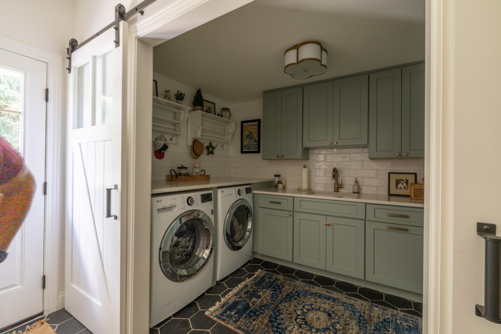 This is an example of an expansive transitional u-shaped laundry room in Detroit with an undermount sink, flat-panel cabinets, white cabinets, quartz benchtops, beige splashback, porcelain splashback, medium hardwood floors, brown floor, white benchtop and wood.