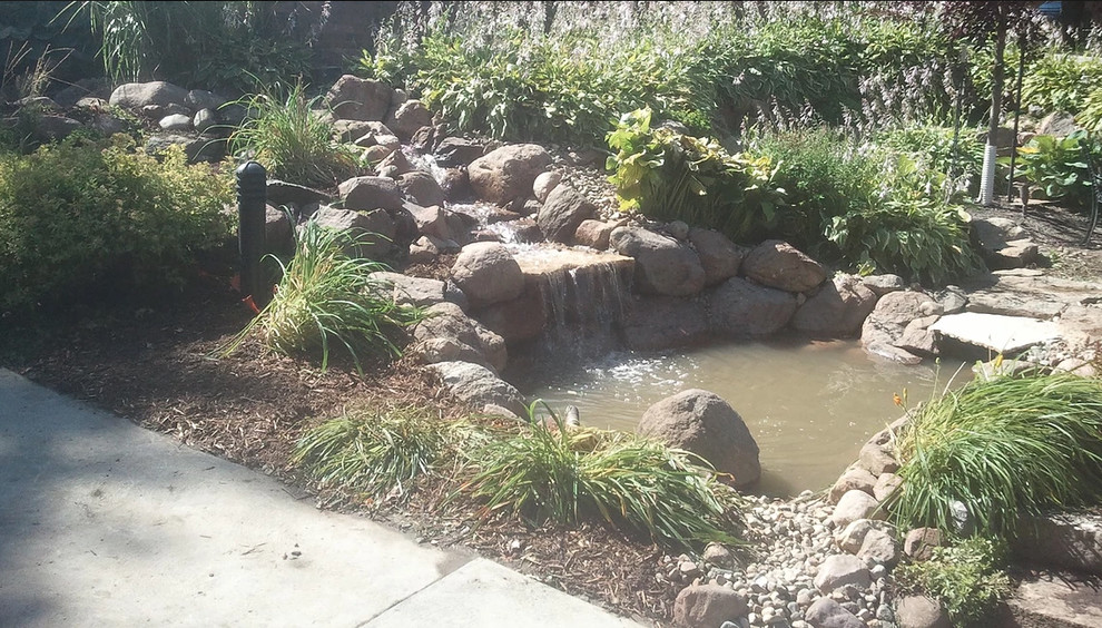 Photo of a mid-sized rustic partial sun backyard gravel formal garden for spring.