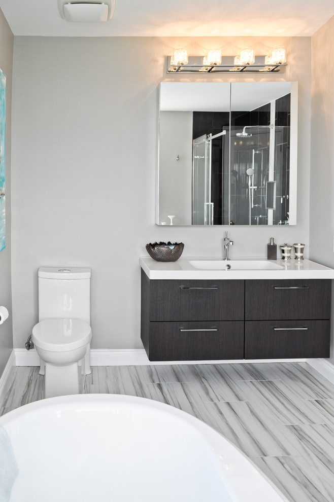 Design ideas for a large transitional master bathroom in Ottawa with a console sink, furniture-like cabinets, dark wood cabinets, solid surface benchtops, a freestanding tub, a corner shower, a two-piece toilet, multi-coloured tile, porcelain tile, grey walls and porcelain floors.
