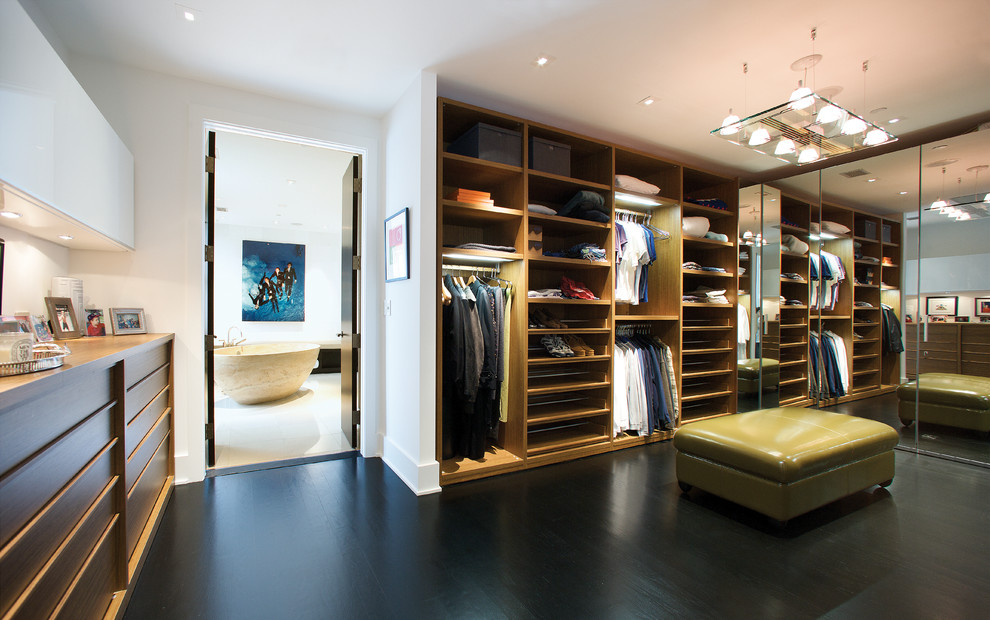 This is an example of a large contemporary gender-neutral walk-in wardrobe in DC Metro with flat-panel cabinets, dark wood cabinets, dark hardwood floors and brown floor.