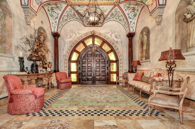 This is an example of an expansive mediterranean foyer in Tampa with beige walls, travertine floors, a double front door, a dark wood front door and yellow floor.