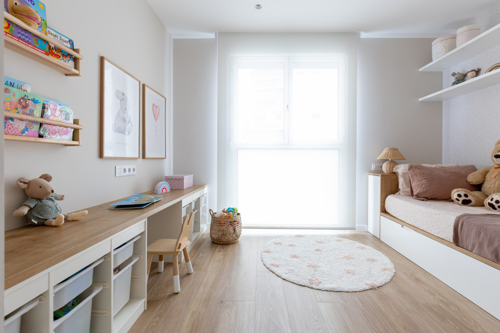 Ejemplo de dormitorio infantil de 4 a 10 años escandinavo grande con paredes beige, suelo de madera clara y suelo marrón