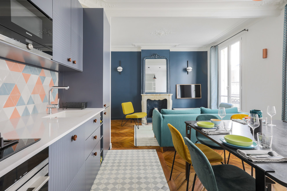 Inspiration for a small contemporary single-wall open plan kitchen in Paris with an integrated sink, flat-panel cabinets, grey cabinets, multi-coloured splashback, stainless steel appliances, no island, grey floor and white benchtop.