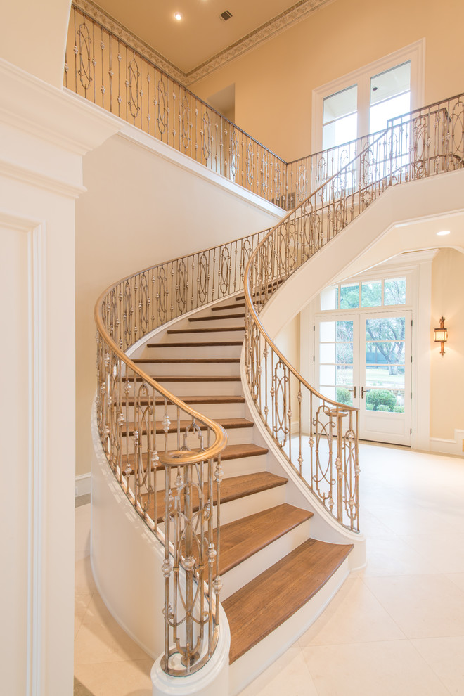 Photo of a large mediterranean wood floating staircase in Dallas with painted wood risers and metal railing.