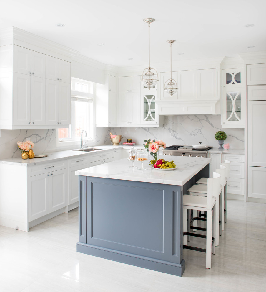 Mid-sized transitional l-shaped open plan kitchen in Toronto with a double-bowl sink, white cabinets, white splashback, stone slab splashback, stainless steel appliances, with island, shaker cabinets, marble floors, white floor, quartz benchtops and white benchtop.