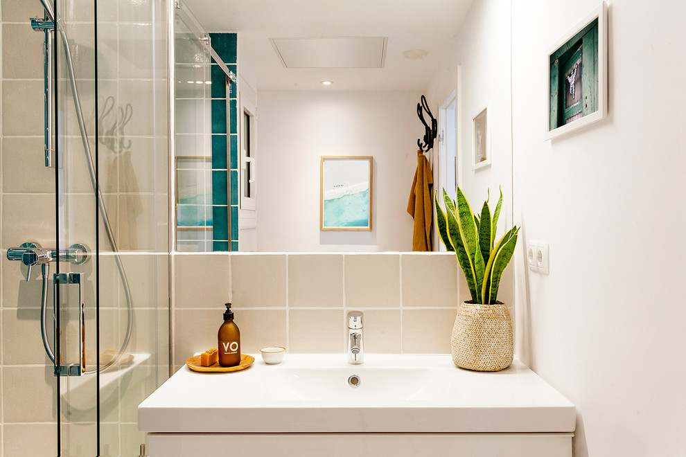 This is an example of a small contemporary master bathroom in Barcelona with white cabinets, an alcove shower, a one-piece toilet, green tile, ceramic tile, white walls, cement tiles, a trough sink, grey floor and a sliding shower screen.