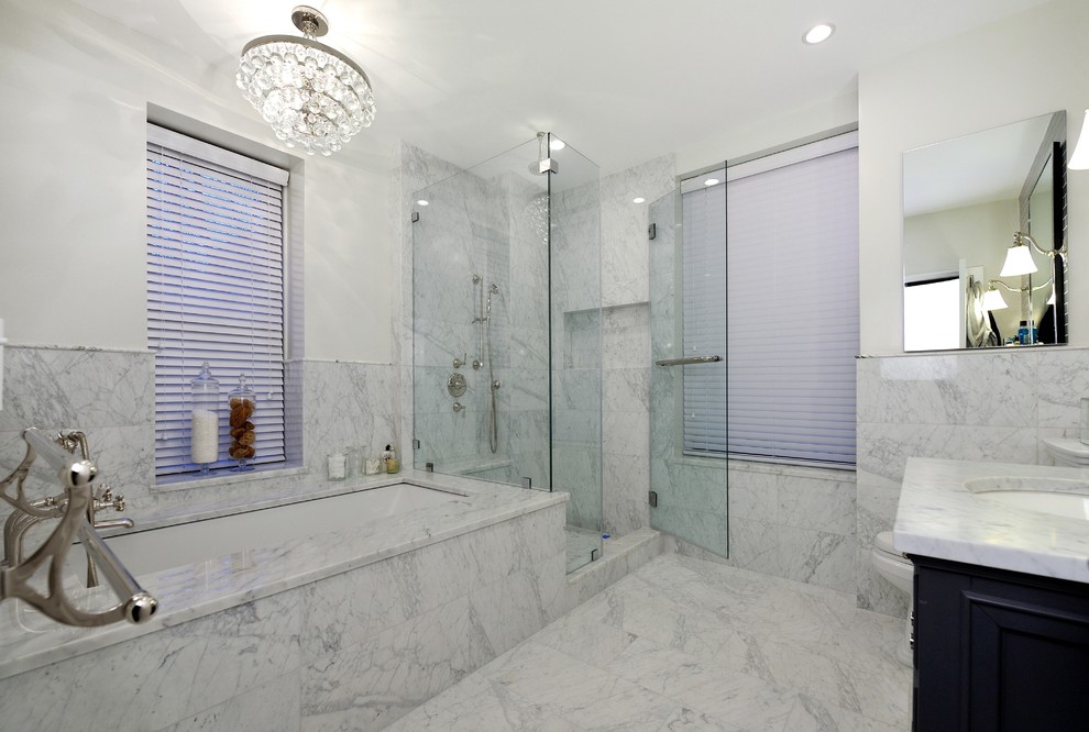 Inspiration for a large contemporary bathroom in New York with an integrated sink, raised-panel cabinets, dark wood cabinets, wood benchtops, a corner tub, a corner shower, a one-piece toilet, gray tile, white walls and marble floors.