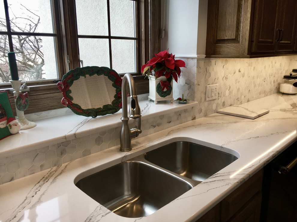 Large transitional u-shaped medium tone wood floor open concept kitchen photo with an undermount sink, recessed-panel cabinets, distressed cabinets, quartz countertops, multicolored backsplash, mosaic tile backsplash, stainless steel appliances and an island