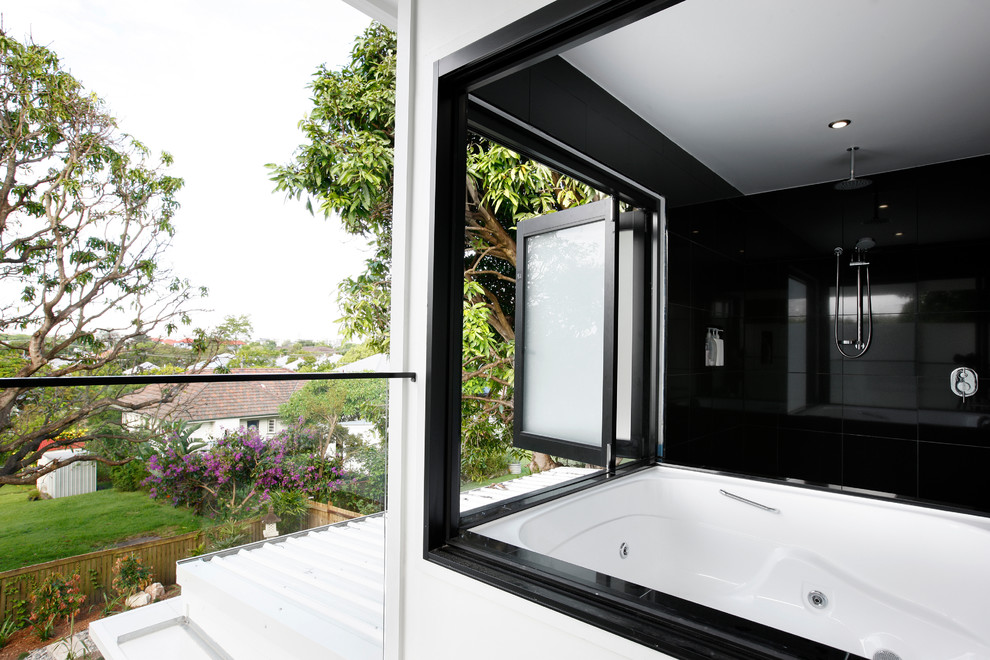 Mid-sized modern master bathroom in Brisbane with a hot tub, an open shower, black tile, ceramic tile, black walls and an open shower.