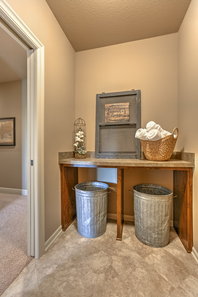 This is an example of a mid-sized traditional laundry cupboard in Kansas City with beige walls and beige floor.
