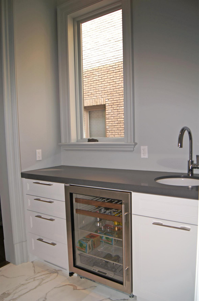 Large transitional l-shaped marble floor, gray floor and coffered ceiling kitchen pantry photo in Toronto with an integrated sink, flat-panel cabinets, stainless steel cabinets, quartz countertops, white backsplash, marble backsplash, stainless steel appliances, gray countertops and an island