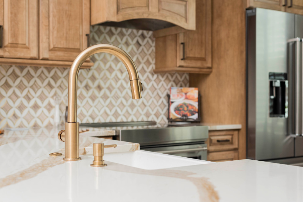 Inspiration for a mid-sized transitional porcelain tile and white floor kitchen remodel in Orlando with a farmhouse sink, recessed-panel cabinets, light wood cabinets, quartz countertops, marble backsplash and stainless steel appliances