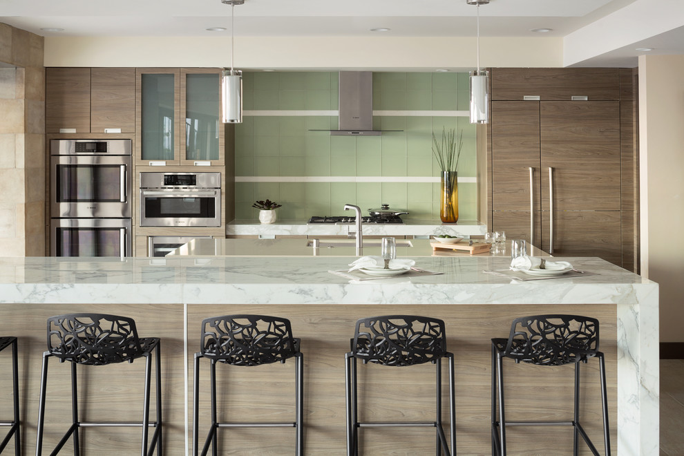 Design ideas for an expansive contemporary galley open plan kitchen in Las Vegas with an undermount sink, flat-panel cabinets, dark wood cabinets, green splashback, glass tile splashback, stainless steel appliances and multiple islands.