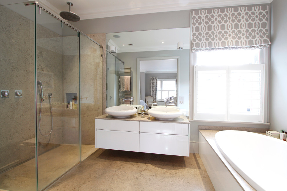 Photo of a mid-sized contemporary master bathroom in London with a vessel sink, flat-panel cabinets, white cabinets, a drop-in tub, an alcove shower and grey walls.